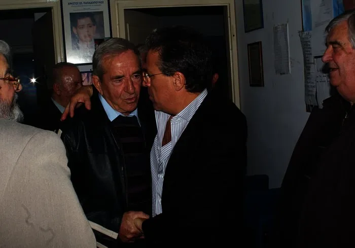 Ο Αργύρης Ντινόπουλος συνομιλεί με ηλικιωμένο άνδρα.