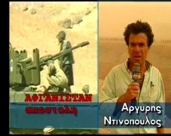 Καρέ τηλεοπτικής μετάδοσης: ο Αργύρης Ντινόπουλος με μικρόφωνο δίπλα σε αντιαεροπορικό πυροβόλο, με τα γραφικά «ΑΦΓΑΝΙΣΤΑΝ αποστολή» και το όνομά του στην οθόνη.
