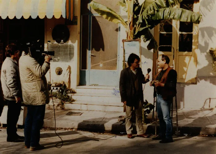 Argyris Dinopoulos on a street report with a film camera, 1980s