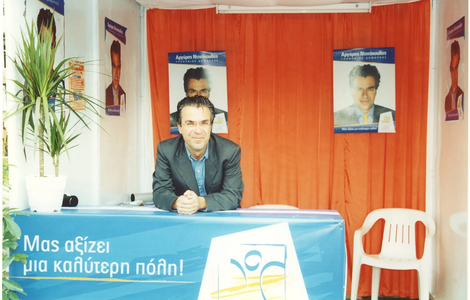 Ο Αργύρης Ντινόπουλος σε εκλογικό κέντρο με αφίσες της υποψηφιότητάς του.