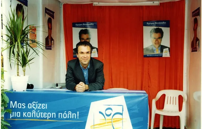 Ο Αργύρης Ντινόπουλος σε εκλογικό κέντρο με αφίσες της υποψηφιότητάς του.