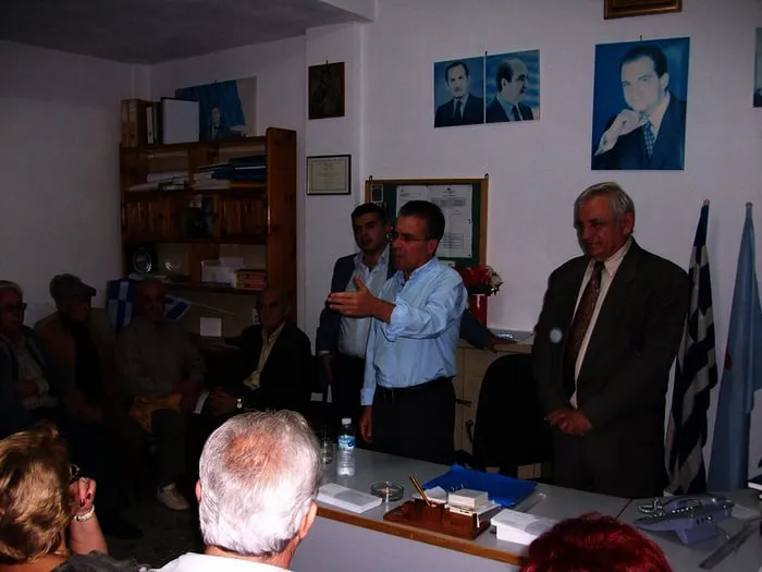 Ο Αργύρης Ντινόπουλος μιλά σε ακροατήριο σε κομματικό γραφείο.
