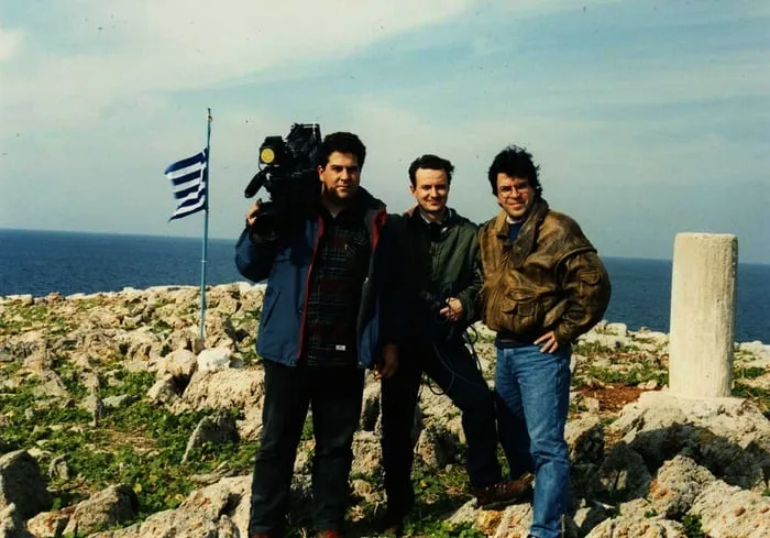 Ο ανταποκριτής Αργύρης Ντινόπουλος με εικονολήπτη και συνάδελφο, με ελληνική σημαία σε βραχονησίδα, Ίμια, 1996.