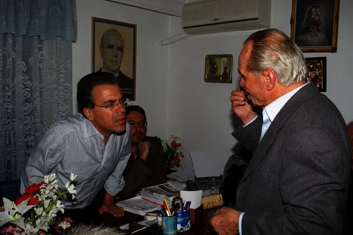 Ο Αργύρης Ντινόπουλος συνομιλεί με ηλικιωμένο άνδρα.