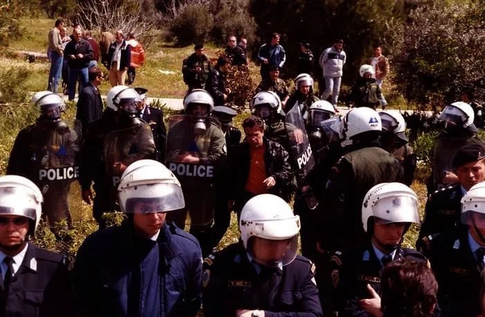 Άνδρες των ΜΑΤ με ασπίδες, ο Αργύρης Ντινόπουλος ανάμεσά τους.